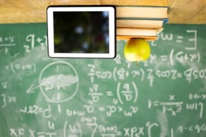 Digital tablet and apple on stack of books